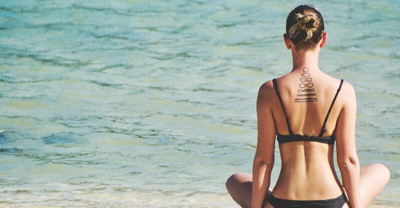 Mulher com tatuagens na praia